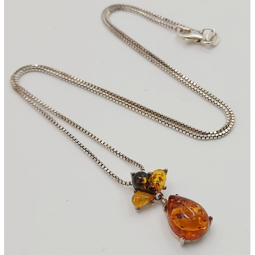 700 - A ‘HOBBS’  AMBER and SILVER PENDANT. Having different shades of Amber set in SILVER and mounted on a... 