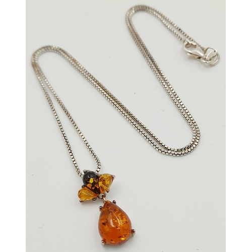 700 - A ‘HOBBS’  AMBER and SILVER PENDANT. Having different shades of Amber set in SILVER and mounted on a... 