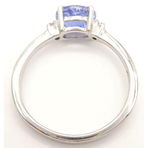 880 - A Sterling Silver Tanzanite and White Sapphire Set Ring Size Q. Set with a 7.5mm Long Oval Cut Tanza... 