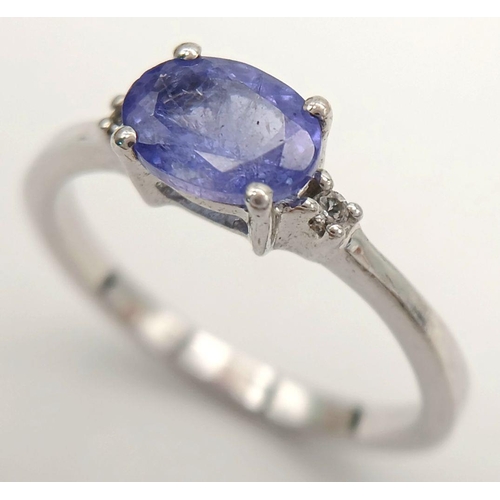 880 - A Sterling Silver Tanzanite and White Sapphire Set Ring Size Q. Set with a 7.5mm Long Oval Cut Tanza... 