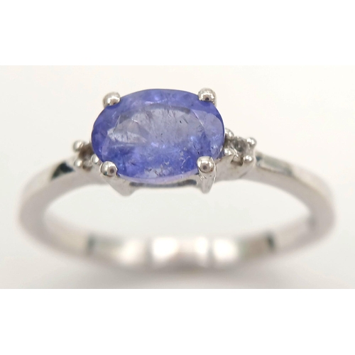 880 - A Sterling Silver Tanzanite and White Sapphire Set Ring Size Q. Set with a 7.5mm Long Oval Cut Tanza... 