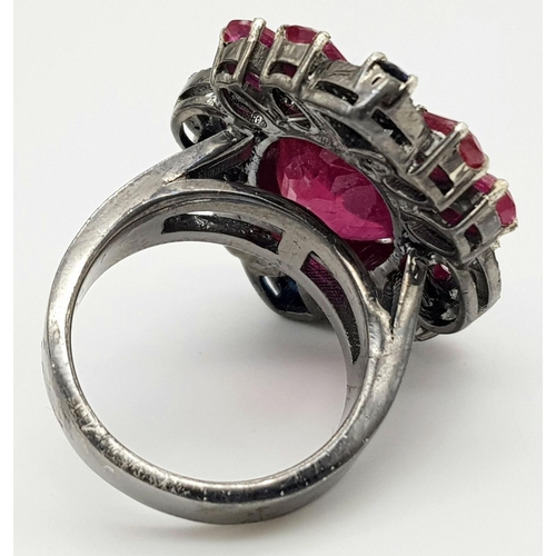 635 - A 925 silver ring with ruby and diamond accents surrounded, in floral design. 15ct Ruby , 0.40ct Dia... 