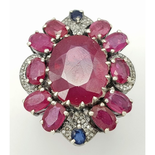 635 - A 925 silver ring with ruby and diamond accents surrounded, in floral design. 15ct Ruby , 0.40ct Dia... 