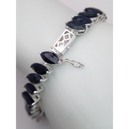 941 - A 925 silver marquise-shaped tennis bracelet set with blue sapphire gemstones, total weight 25g. Loo... 