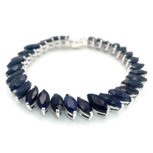 941 - A 925 silver marquise-shaped tennis bracelet set with blue sapphire gemstones, total weight 25g. Loo... 