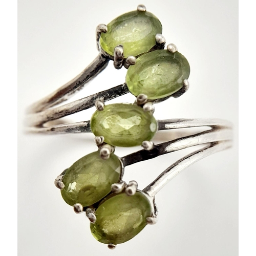 985 - A Sterling Silver and Peridot Set Five Stone Statement Ring Size R. Set with Five 5mm Long Oval Cut ... 