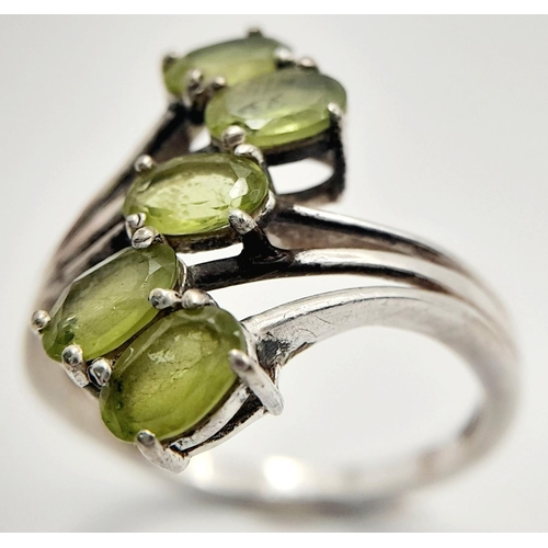 985 - A Sterling Silver and Peridot Set Five Stone Statement Ring Size R. Set with Five 5mm Long Oval Cut ... 