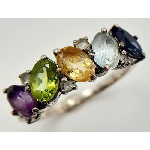 999 - A Sterling Silver Multi-Gemstone Set Ring Size P. The Ring is set with Oval and Round Cut Blue ands ... 