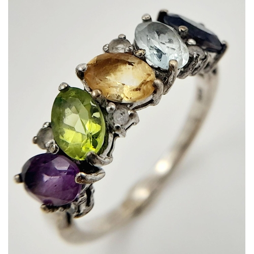 999 - A Sterling Silver Multi-Gemstone Set Ring Size P. The Ring is set with Oval and Round Cut Blue ands ... 