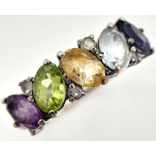 999 - A Sterling Silver Multi-Gemstone Set Ring Size P. The Ring is set with Oval and Round Cut Blue ands ... 