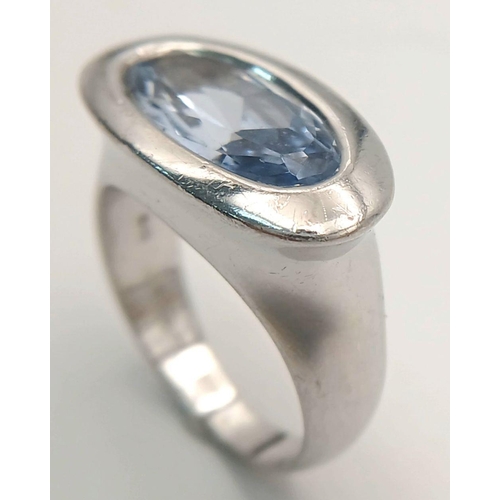 1175 - A Sterling Silver Blue Topaz Set Modernist Design Ring Size M1/2. Set with a 1.5cm Long Oval Cut Blu... 