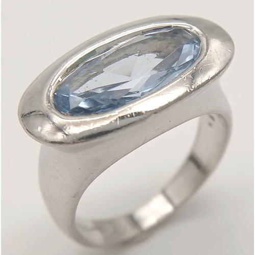 1175 - A Sterling Silver Blue Topaz Set Modernist Design Ring Size M1/2. Set with a 1.5cm Long Oval Cut Blu... 