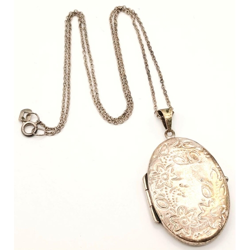 1507 - A vintage 925 silver Oval locket pendant with floral motif engravings. Set on silver belcher chain. ... 