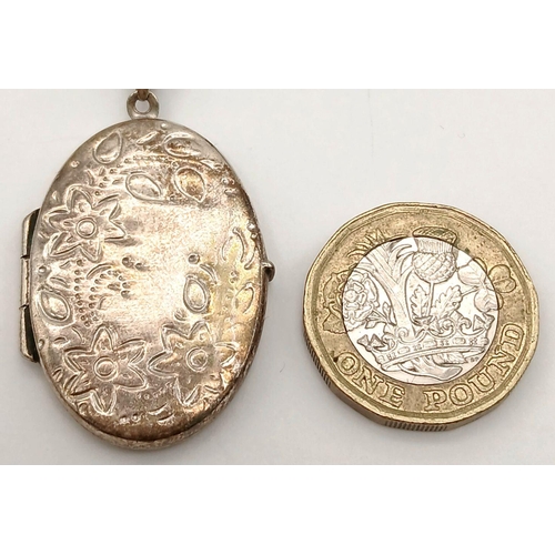 1507 - A vintage 925 silver Oval locket pendant with floral motif engravings. Set on silver belcher chain. ... 