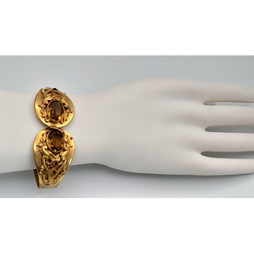 1611 - A selection of jewellery items, including a gold-tone open bangle with smoky quartz setting, a blue ... 