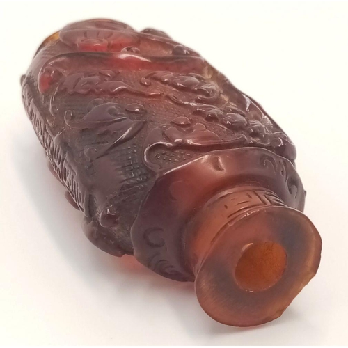 642 - An Antique Chinese Amber Hand-Carved Snuff Bottle. 6.5cm tall.