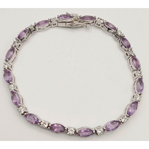 697 - A Sterling Silver Amethyst and Clear Stone Tennis Bracelet 20cm Length. Set with Sixteen 6mm Long Ov... 