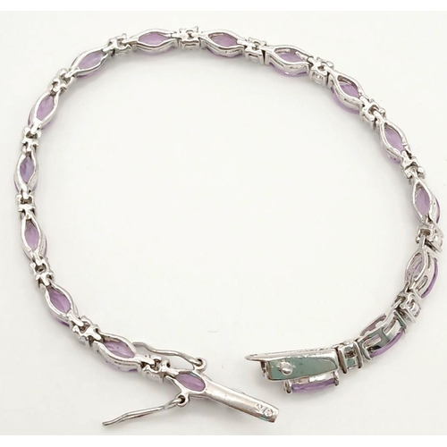 697 - A Sterling Silver Amethyst and Clear Stone Tennis Bracelet 20cm Length. Set with Sixteen 6mm Long Ov... 