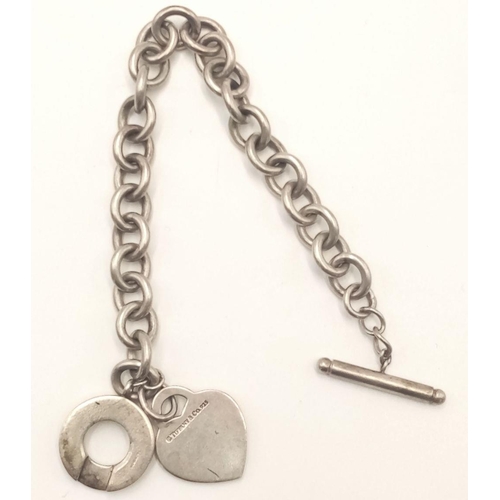 759 - A Vintage Return to Tiffany and Co. Sterling Silver Bracelet. Toggle clasp with hanging Tiffany hear... 