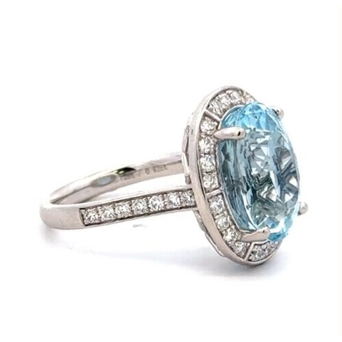 528 - A Platinum AQUA and DIAMOND Cluster Ring. 7.12ct claw set round shape Aqua centre, decorated with 0.... 