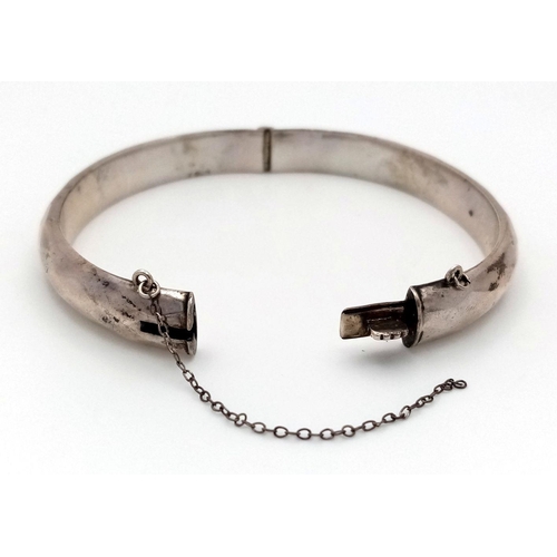 1472 - A vintage sterling silver click-on bangle (safety chain A/F). Full Sheffield hallmarks. Total weight... 