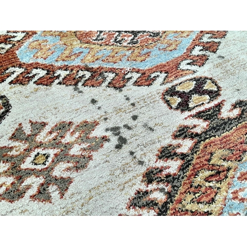 928 - A Cream Cashmere Patterned Rug, Measuring 200 x 290cm. See photos for condition and design.