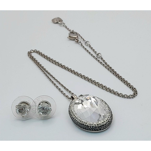 1612 - A matching set of Swarovski large Crystal pendant on chain and a pair of stone set earrings.