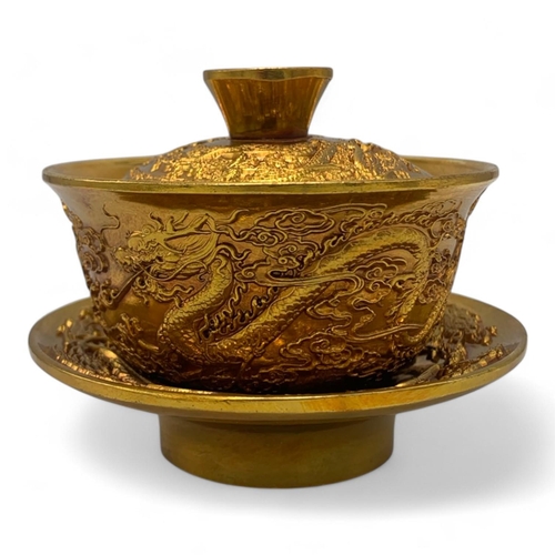 1376 - A Chinese Gold-Toned Dragon and Phoenix Tea Bowl with Saucer.  
Gold-toned bronze exterior with intr... 