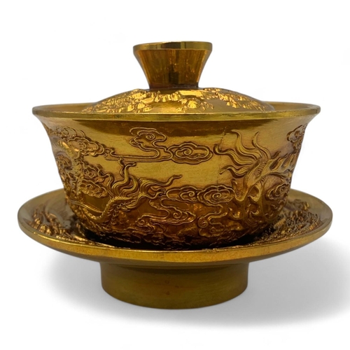 1376 - A Chinese Gold-Toned Dragon and Phoenix Tea Bowl with Saucer.  
Gold-toned bronze exterior with intr... 