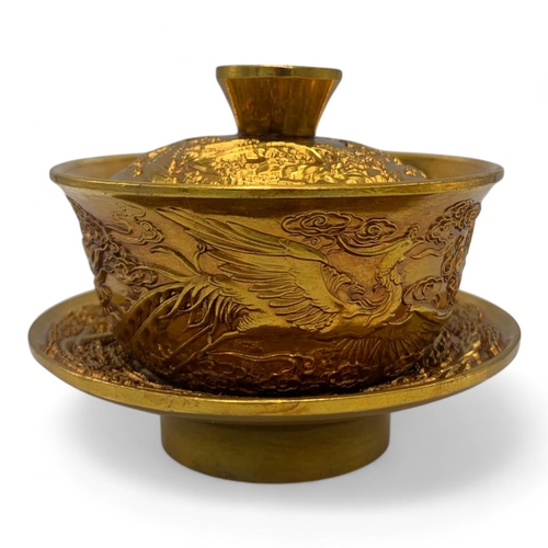 1376 - A Chinese Gold-Toned Dragon and Phoenix Tea Bowl with Saucer.  
Gold-toned bronze exterior with intr... 