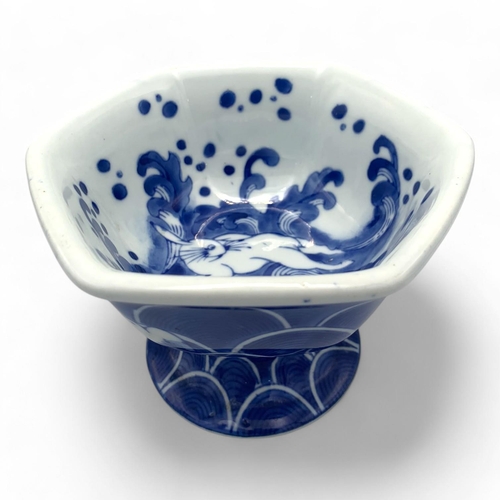 1411 - An antique Japanese Blue and White Porcelain Pedestal Bowl. Hexagonal form with blue wave patterns a... 