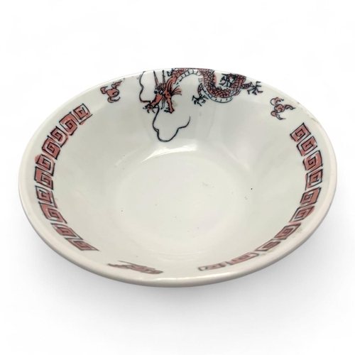 1418 - A Japanese Porcelain Dragon Bowl.  
White porcelain with pink and black dragon motif exterior, adorn... 