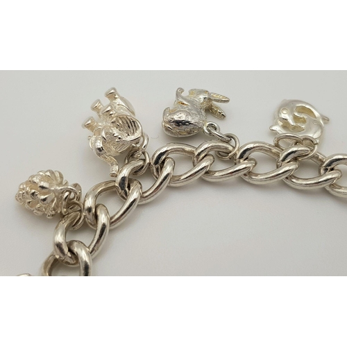 632 - A beautiful Solid Silver 925 Charm Bracelet, with 12 charms, 40 grams, 19cm. Condition: Like New.