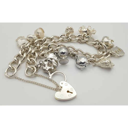 632 - A beautiful Solid Silver 925 Charm Bracelet, with 12 charms, 40 grams, 19cm. Condition: Like New.