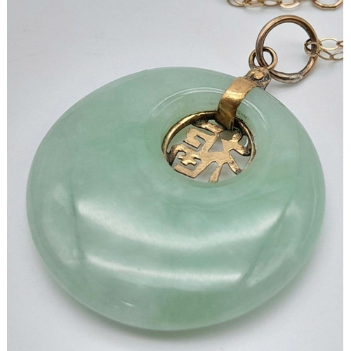 744 - A jade pendant necklace with 9ct disappearing gold chain. 41cm in length and 5g total weight. 2.4cm ... 