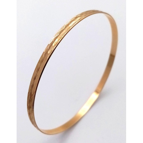 374 - A 9K Yellow Gold Bangle. Geometric pattern. 63mm inner diameter. 5.75g weight.