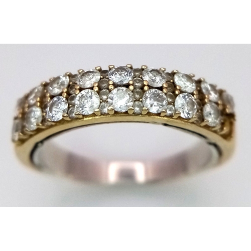 477 - An 18K Yellow Gold Two Row Diamond Ring. 19 round cut diamonds with diamond spacers. Note: There is ... 