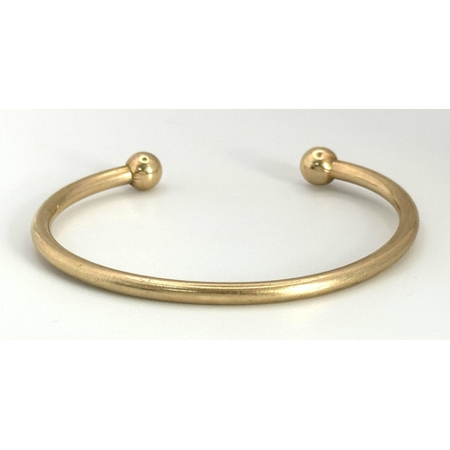 120 - A 9K Yellow Gold Cuff Bangle. Bauble end style. 25.15g weight.