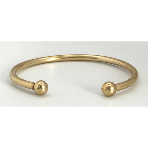 120 - A 9K Yellow Gold Cuff Bangle. Bauble end style. 25.15g weight.