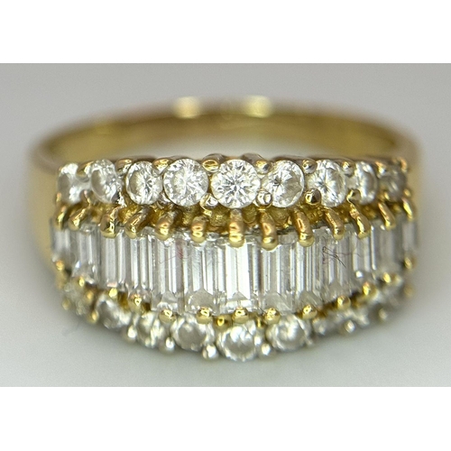 16 - An 18K Yellow Gold Three Row Diamond Ring. An extravagant central row of baguette cut diamonds with ... 