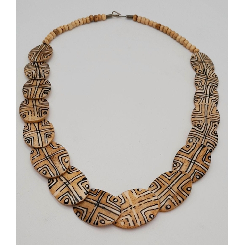 192 - A vintage, Senegalese, tribal bone necklace with hand painted geometric designs. Length: 65 cm, weig... 