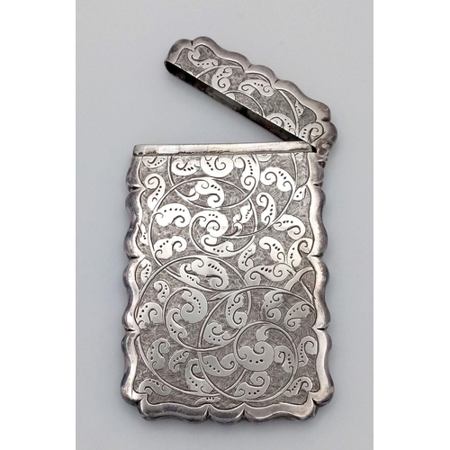 29 - An Antique Victorian Sterling Silver Card Case. Engraved scroll design with empty cartouche. Hinge w... 