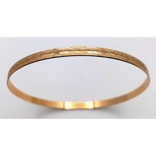 374 - A 9K Yellow Gold Bangle. Geometric pattern. 63mm inner diameter. 5.75g weight.