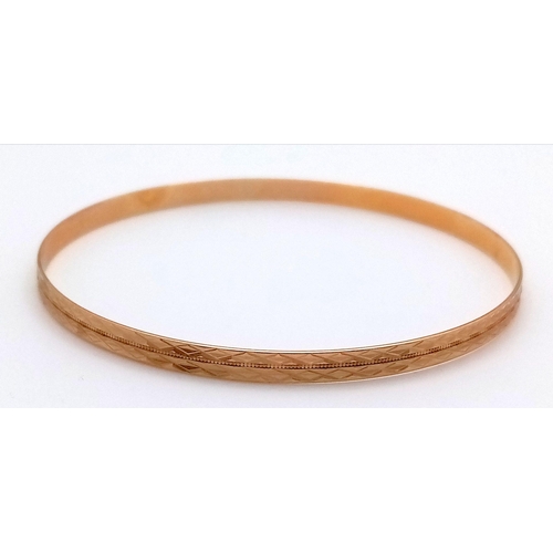 374 - A 9K Yellow Gold Bangle. Geometric pattern. 63mm inner diameter. 5.75g weight.