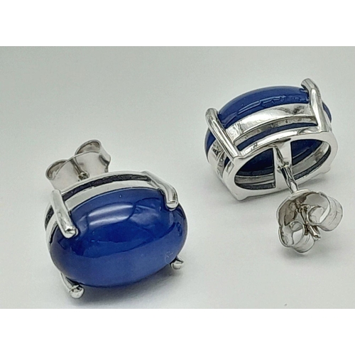 58 - A mesmerising, sterling silver, pair of earrings with a large blue, six ray star sapphire cabochon e... 