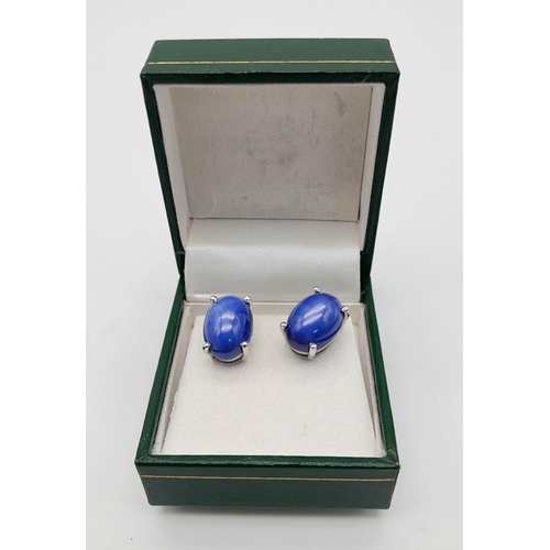 58 - A mesmerising, sterling silver, pair of earrings with a large blue, six ray star sapphire cabochon e... 