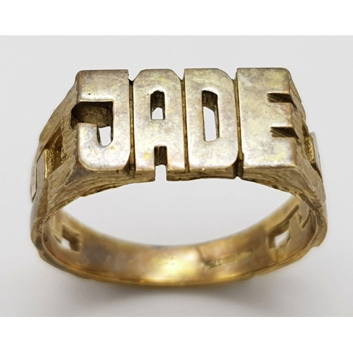 1353 - A 9K Gold 'Jade' Name Ring. Size M 1/2. 3.7g weight.