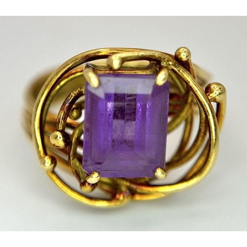 225 - A Vintage 18k Yellow Gold Amethyst Ring. A central 3ct emerald cut amethyst amongst an abstract swir... 