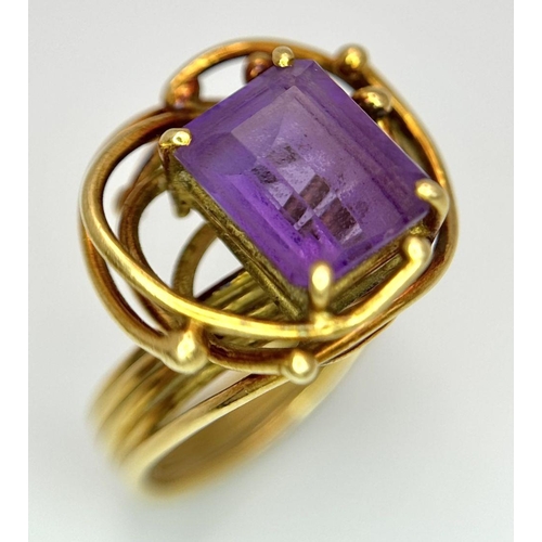 225 - A Vintage 18k Yellow Gold Amethyst Ring. A central 3ct emerald cut amethyst amongst an abstract swir... 