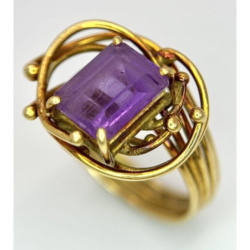 225 - A Vintage 18k Yellow Gold Amethyst Ring. A central 3ct emerald cut amethyst amongst an abstract swir... 